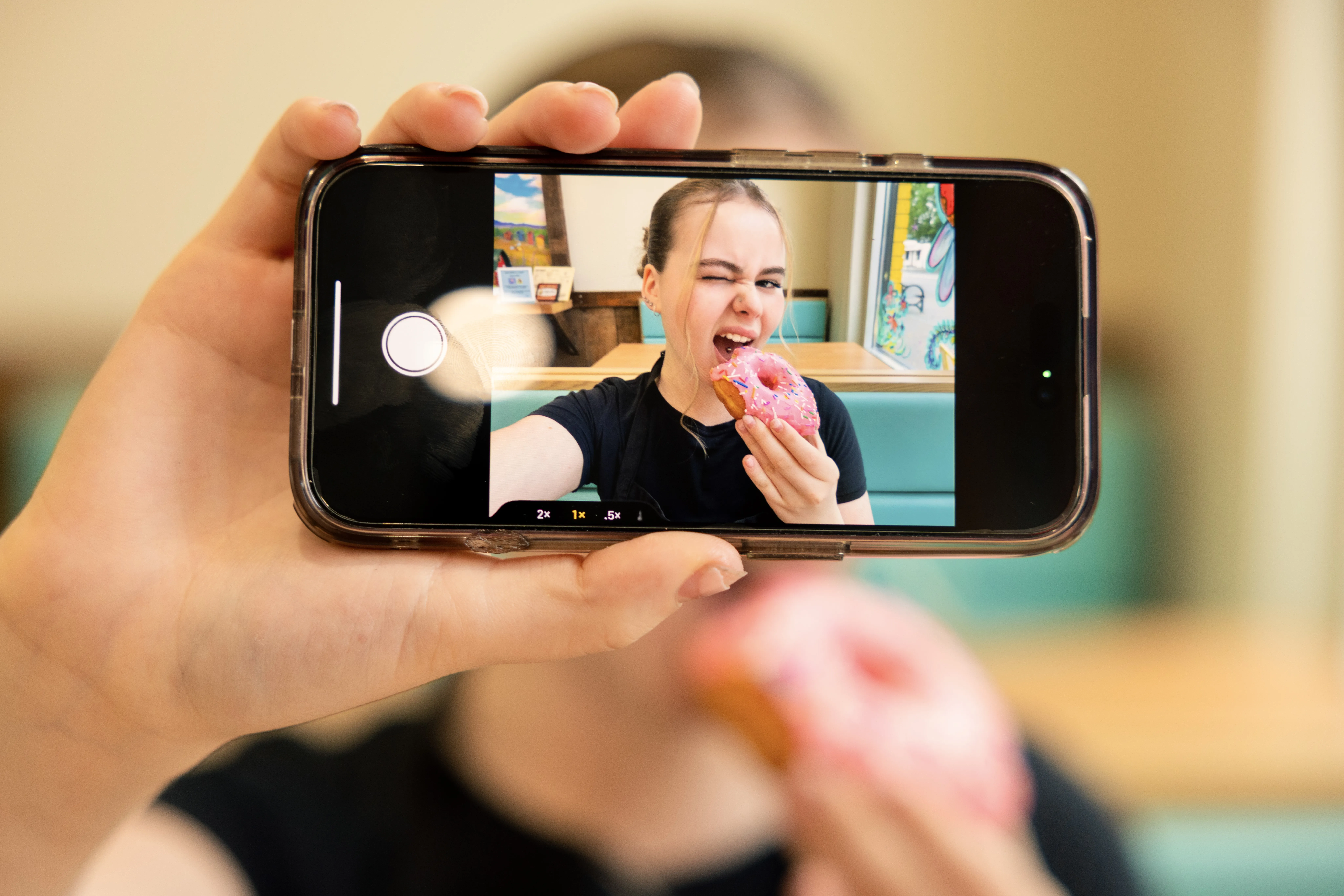 A woman taking a selfie with a donut